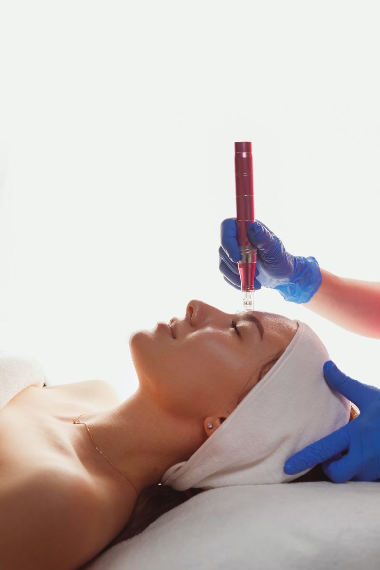 Beautician is using dermapen on woman face skin, side view